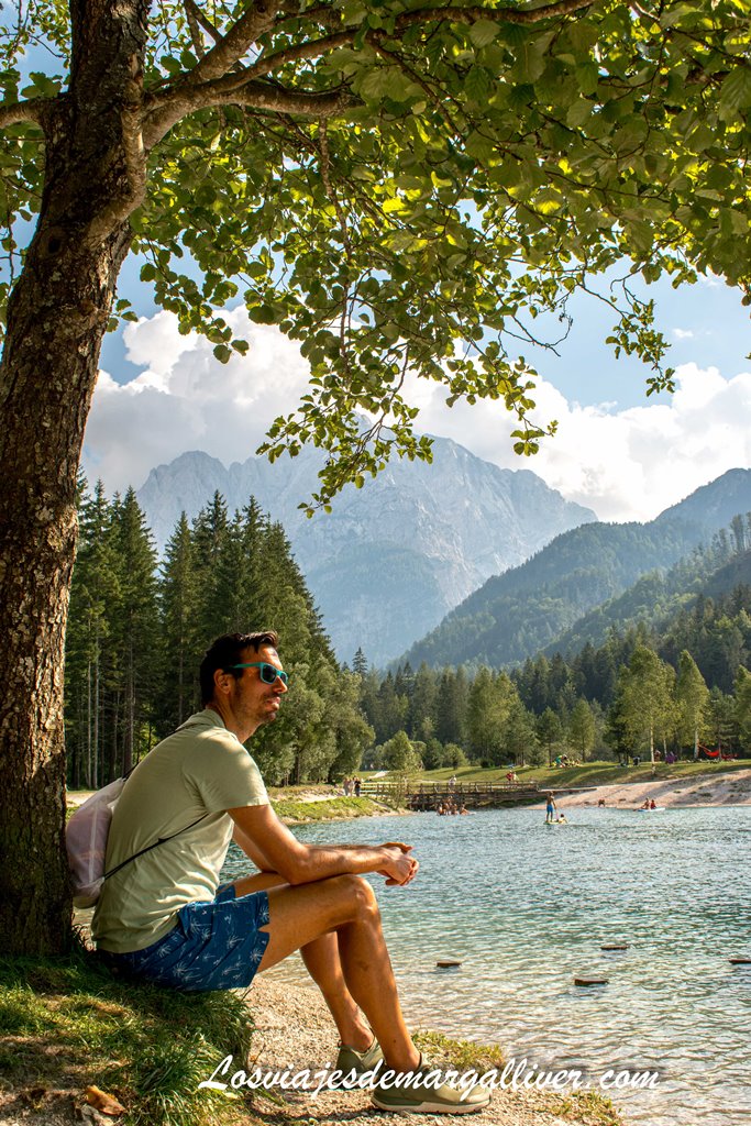 Kike sentado junto a un árbol mirando el precioso lago Jasna en Eslovenia Kike sentado junto a un árbol mirando el precioso lago Jasna en Eslovenia - Los viajes de Margalliver